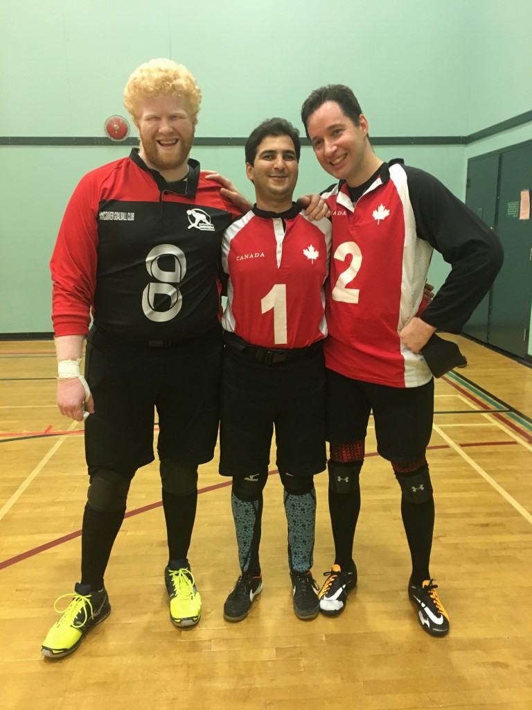 Brendan Gaulin, Ahmad Zeividavi, and Doug Ripley pose in a gym in their red, black and white jerseys
